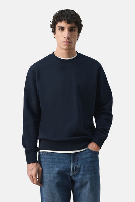 Zwarte sweater van MANGO, gedragen met een wit T-shirt en blauwe jeans.
