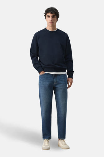 Zwarte sweater met ronde hals van MANGO, gedragen met jeans en crèmekleurige schoenen.