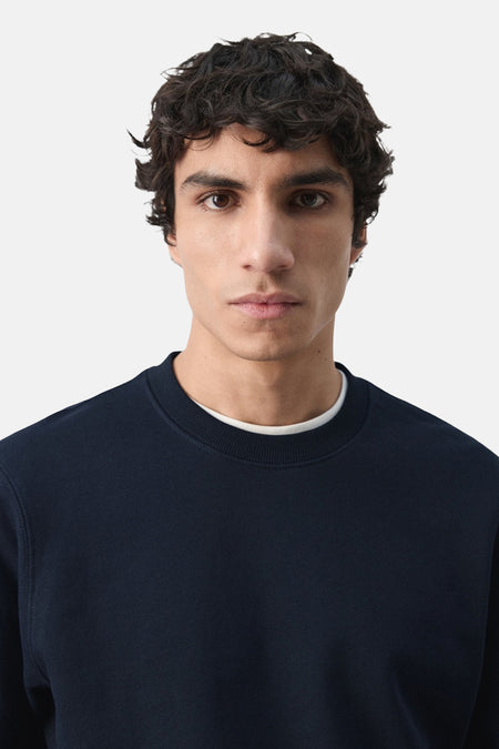 Zwarte sweater met ronde hals van MANGO, met een witte kraag eronder.