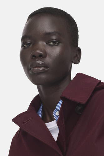 Bordeaux korte jas van MANGO, met knoopsluiting en een blauw-wit gestreept overhemd eronder.