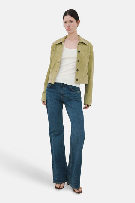 Débardeur blanc de MANGO, porté sous une veste kaki et un jean ample.