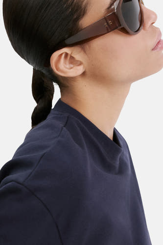 Blauw T-shirt van MANGO, met korte mouwen en ronde hals, gedragen met bruine zonnebril.