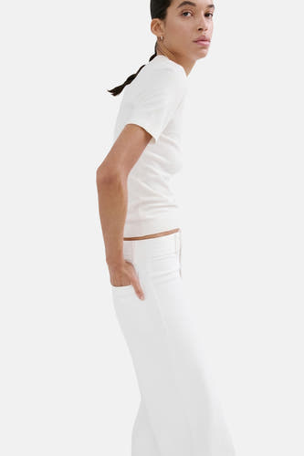 Jean large blanc de MANGO, coupe ajustée avec la main dans la poche, combiné avec une chemise blanche.