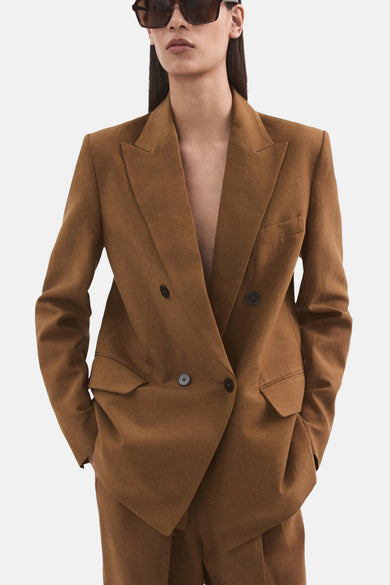 Blazer marron de MANGO avec fermeture croisée, revers pointu, poche poitrine et poches à rabat.
