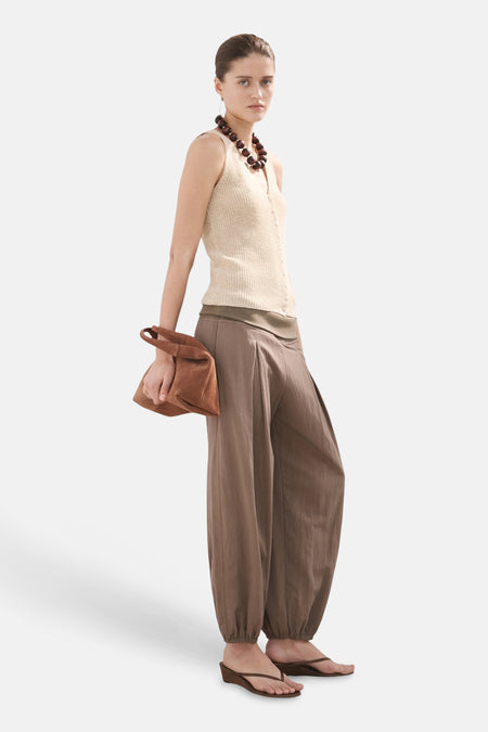 Haut sans manches beige de MANGO, avec de fines côtes et une fermeture à boutons sur le devant.