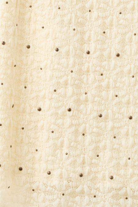 Jupe longue écru de MANGO avec un motif en dentelle et des clous bronze.