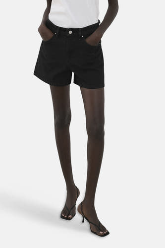 Short noir de MANGO, vu de dos avec une chemise blanche et une ceinture.