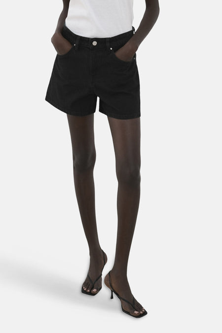 Short noir de MANGO, vu de dos avec une chemise blanche et une ceinture.