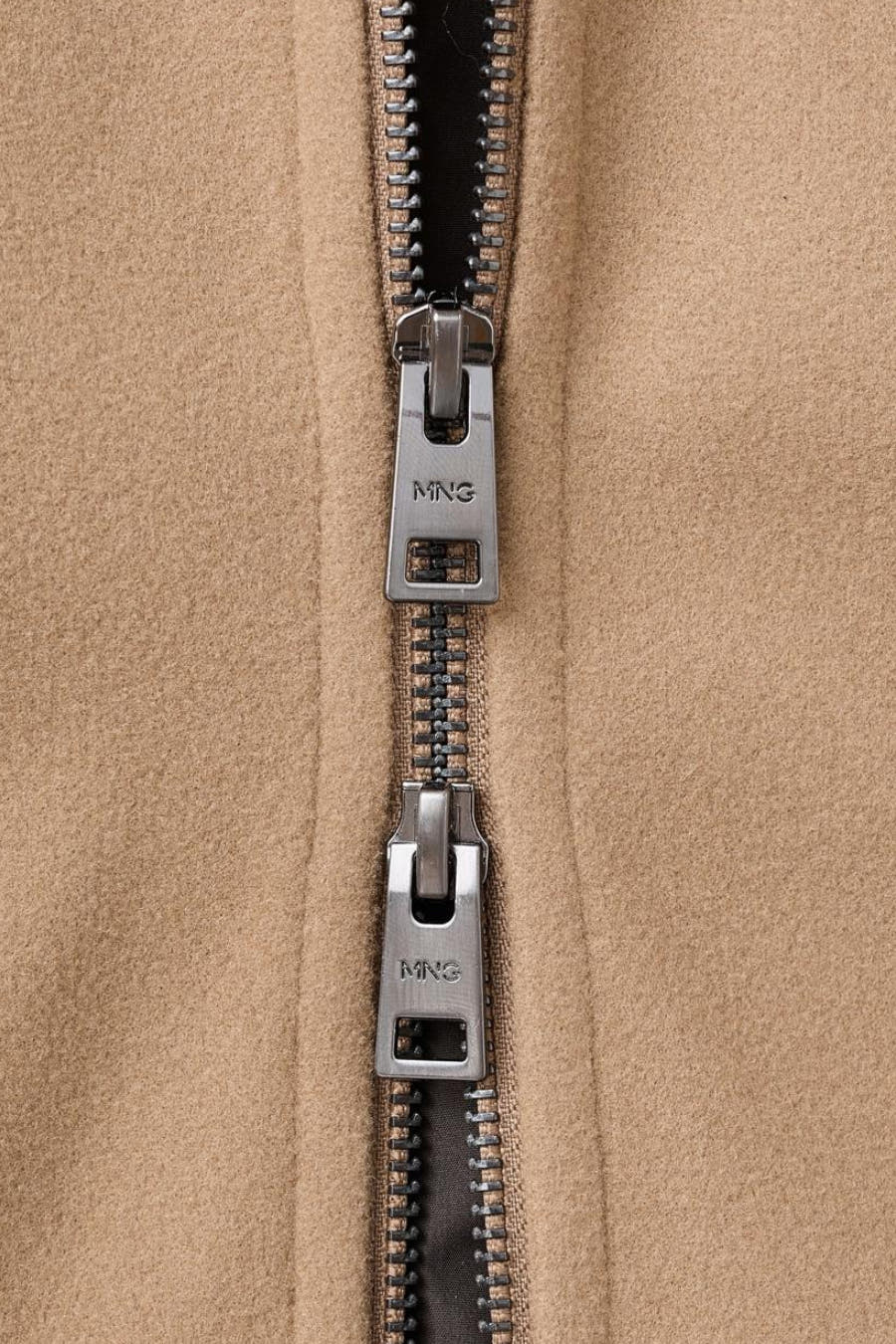 Beige korte jas van MANGO, met een metalen rits en merklogo op de ritstrekker.