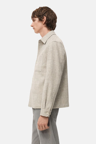 Manteau court beige de MANGO, avec un motif à carreaux, des manches longues et une poche poitrine, en vue latérale.
