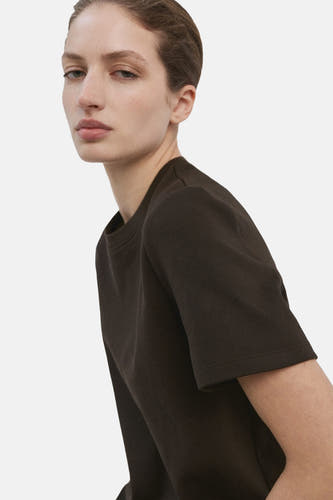 T-shirt marron à manches courtes de MANGO, vu de dos, associé à un jean foncé à jambes larges.