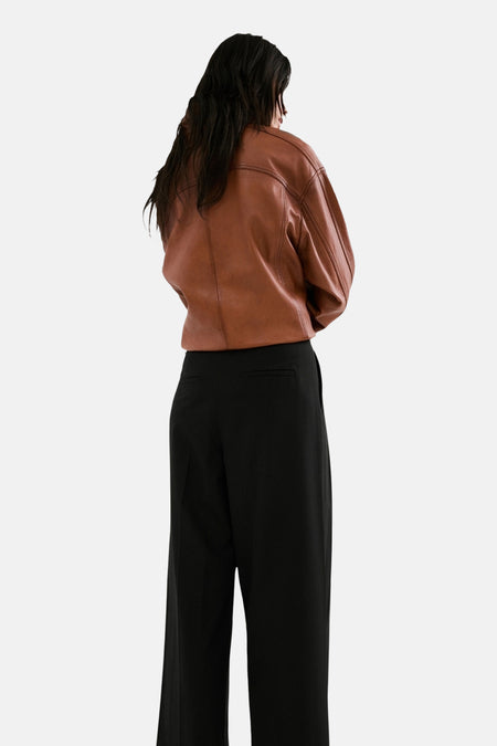 Zwarte broek van MANGO, met wijde pijpen en een hoge taille, van achteren gezien.