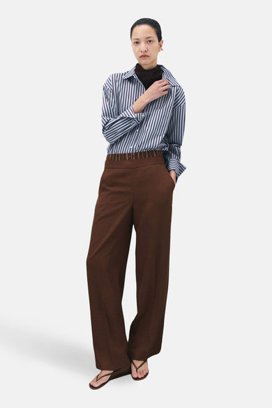 Veelkleurig overhemd met lange mouwen van MANGO, gedragen met bruine pantalon en bruine teenslippers.