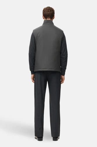 Grijs bodywarmer van MANGO, met een kraag en zichtbaar over een donkergrijze trui en pantalon gedragen.
