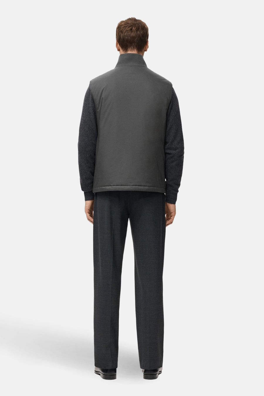 Grijs bodywarmer van MANGO, met een kraag en zichtbaar over een donkergrijze trui en pantalon gedragen.