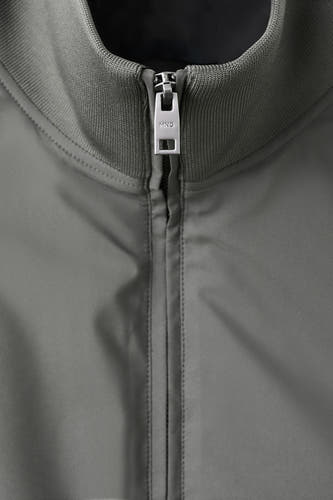Grijs bodywarmer van MANGO, met een gladde textuur en een zilverkleurige rits aan de voorkant.
