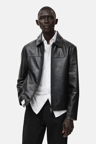 Korte zwarte jas van MANGO, gedragen over een wit overhemd en een zwarte broek.