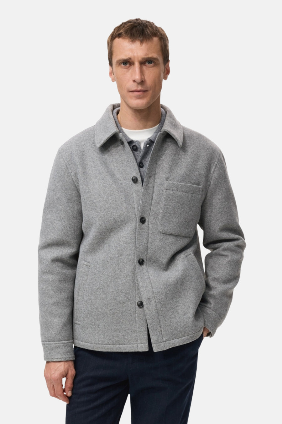 Manteau court gris de MANGO, vu de derrière, avec un pantalon foncé et des chaussures noires.