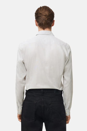 Grijs overhemd met lange mouwen van MANGO, met een gestreept patroon en zwarte broek.