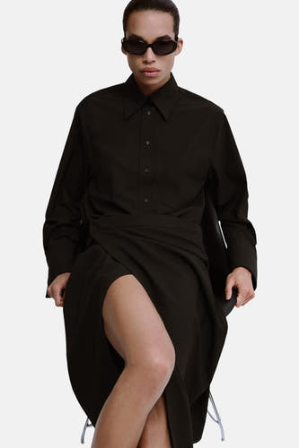 Bruin hemd met lange mouwen van MANGO, gedragen met een rok met split en een zonnebril.
