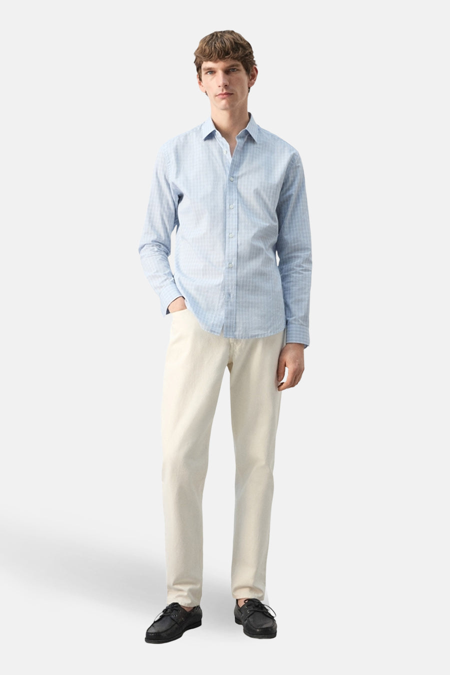 Chemise multicolore à manches longues de MANGO, avec un motif à carreaux subtil, portée avec un pantalon de couleur crème et des chaussures noires.