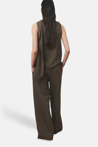 Bruine broek van MANGO, met wijde pijpen en verticale lijnen, gezien van achteren.