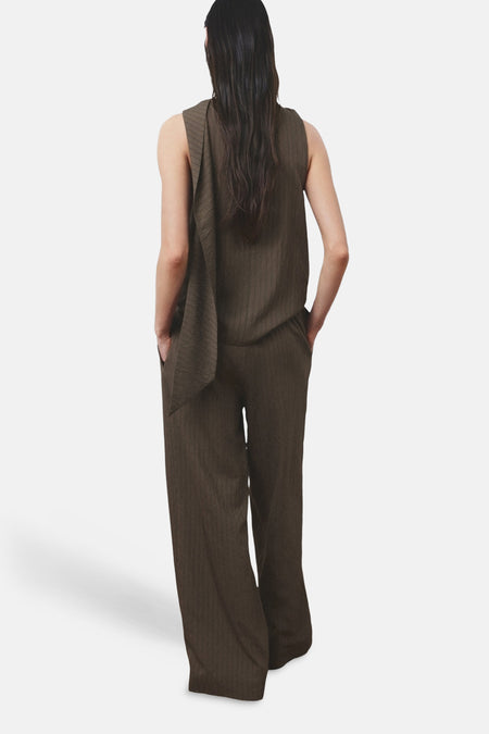 Bruine broek van MANGO, met wijde pijpen en verticale lijnen, gezien van achteren.