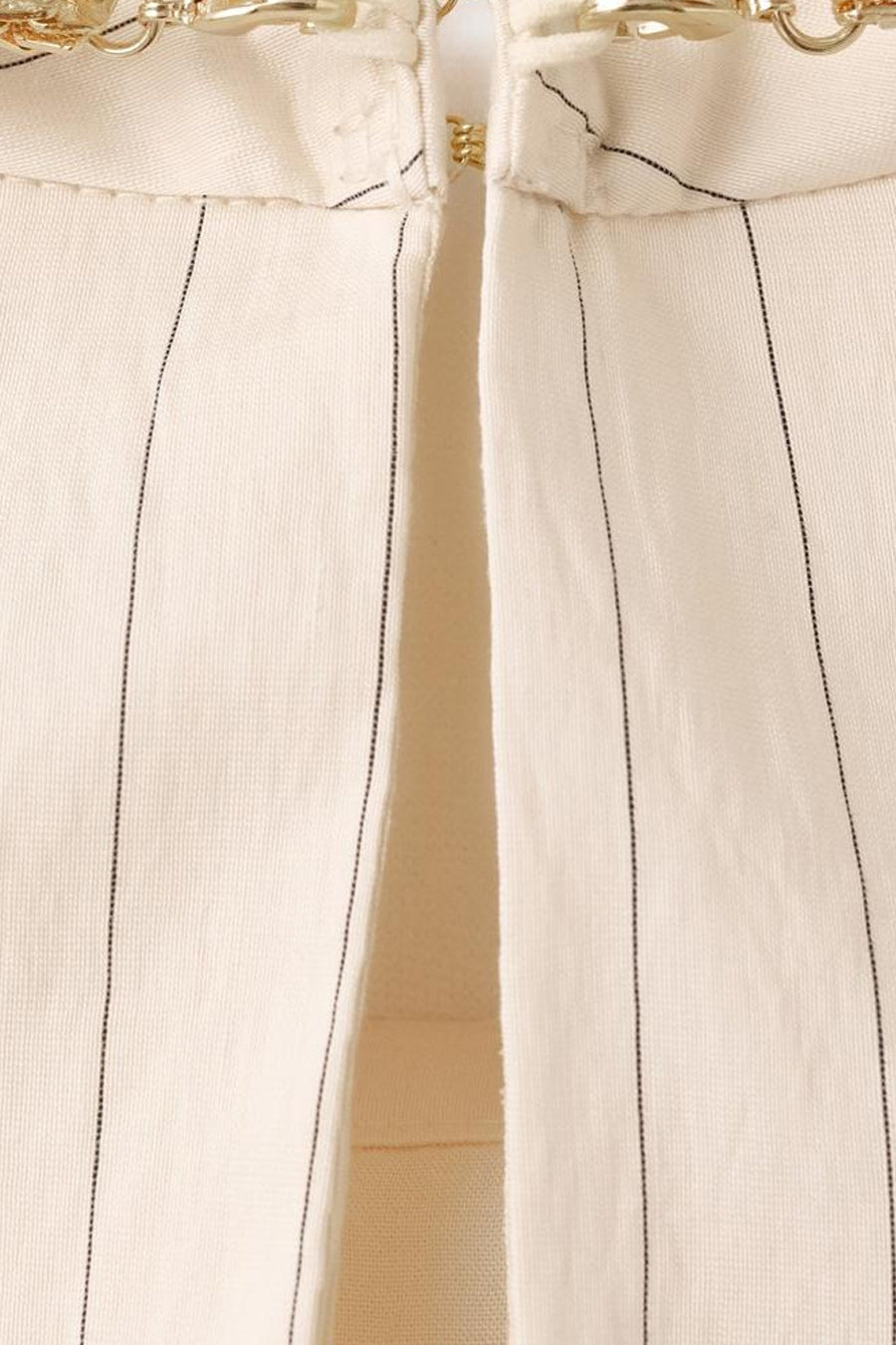 Blouse écru sans manches de MANGO, avec fines rayures verticales et détails décoratifs dorés.