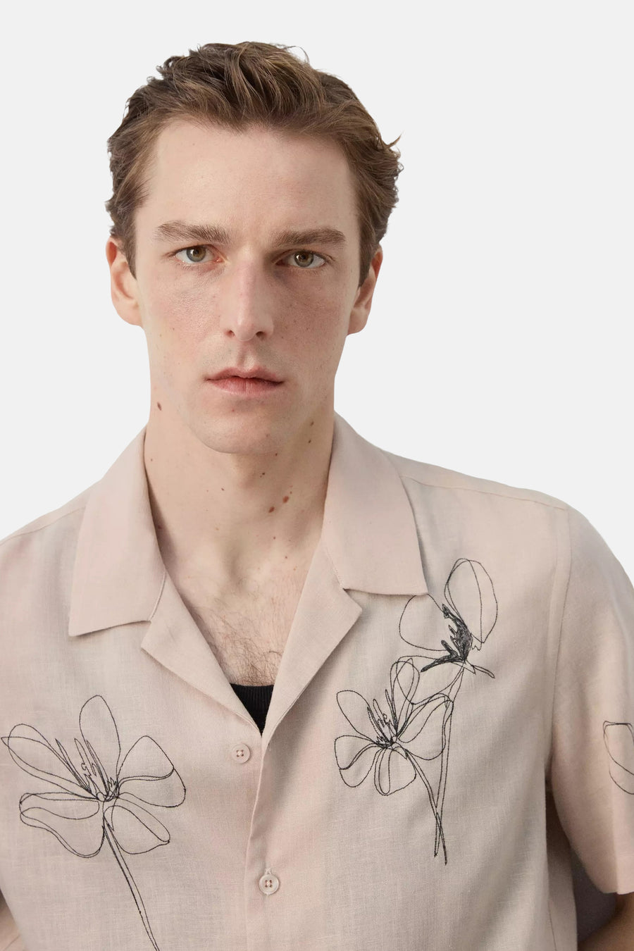 Beige hemd met korte mouwen van MANGO, met open kraag, lichte textuur en abstracte zwarte bloemborduursels.