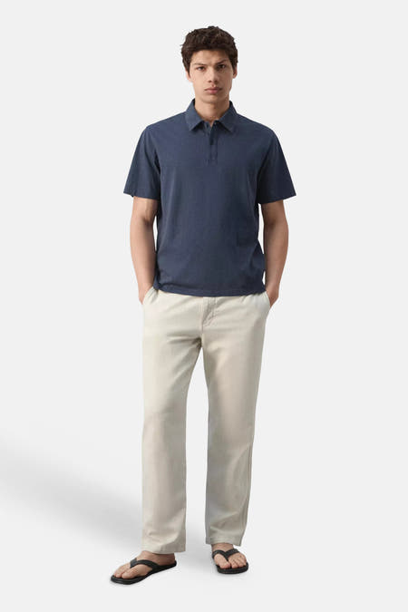 Blauwe polo van MANGO met korte mouwen en kraag, gecombineerd met een lichte broek.