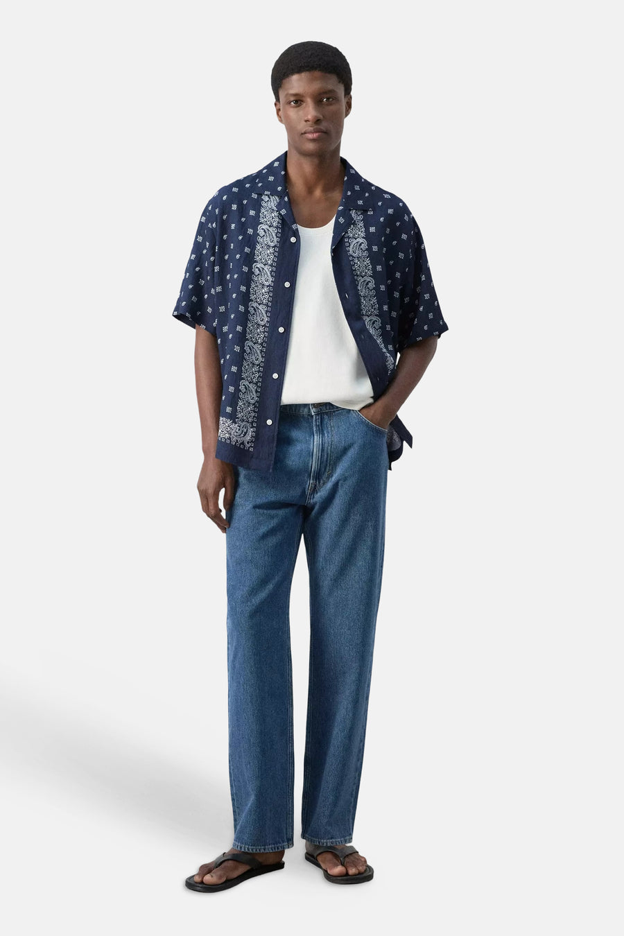 Blauw hemd met korte mouwen van MANGO, met wit paisley- en ruitjespatroon, open gedragen over een wit onderhemd.