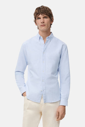 Blauw gestreept overhemd met lange mouwen van MANGO, gedragen met een beige broek.
