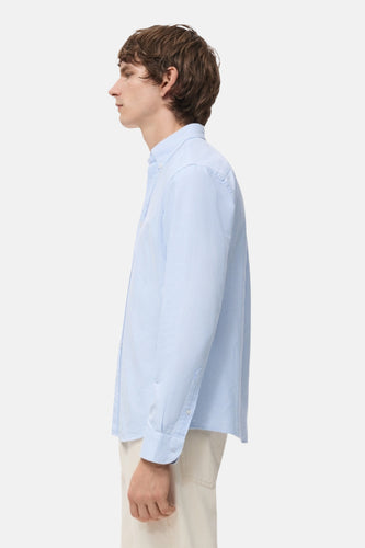 Blauw gestreept overhemd met lange mouwen van MANGO, in zij-aanzicht, gedragen met een beige broek.
