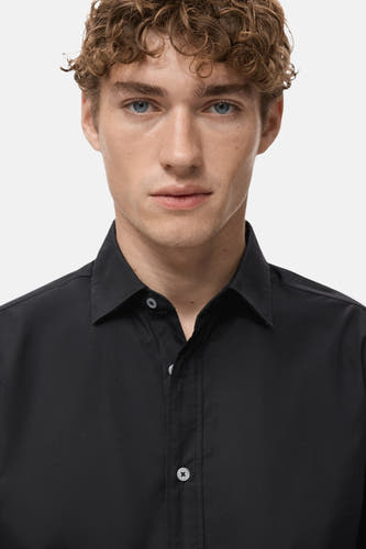 Chemise noire à manches longues de MANGO, design simple avec col boutonné.