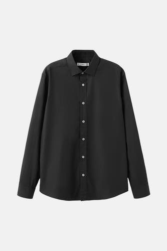 Chemise noire à manches longues de MANGO, avec une fermeture à boutons blancs et un col classique.