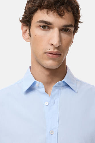 Chemise bleue à manches longues de MANGO, avec un col classique et une fermeture à boutons.