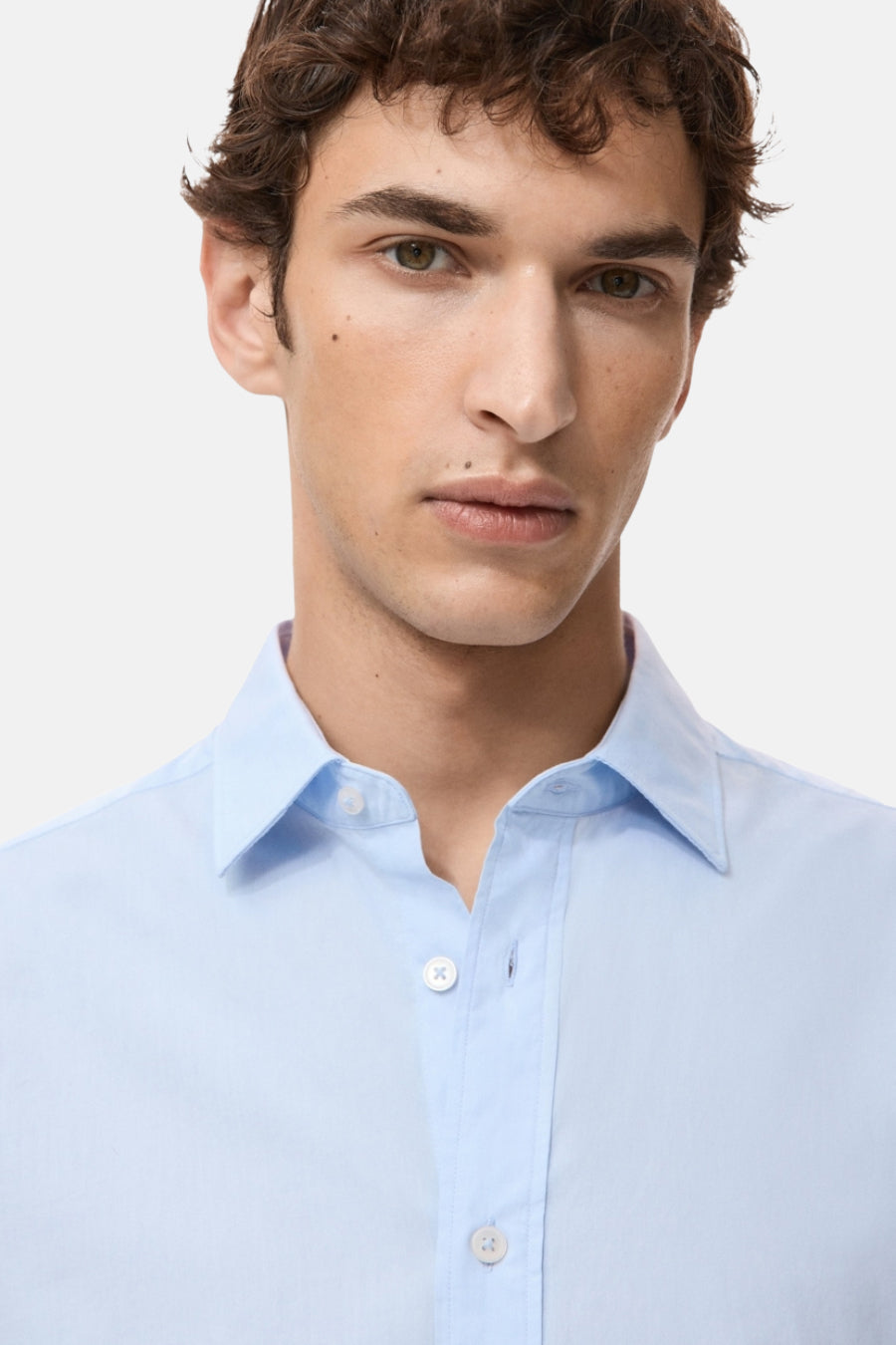 Chemise bleue à manches longues de MANGO, avec un col classique et une fermeture à boutons.