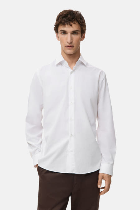 Wit overhemd met lange mouwen van MANGO, gedragen met bruine broek.