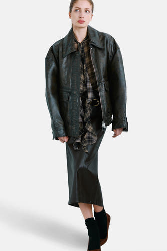 Multikleurige blouse met lange mouwen van MANGO, met een ruitpatroon en gedragen onder een zwarte leren jas en rok.
