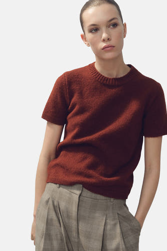 Sweat-shirt marron avec col rond de MANGO, vu de derrière avec une coiffure serrée.