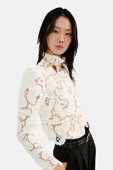 Chemisier blanc à manches longues de MANGO, avec un motif floral en dentelle.