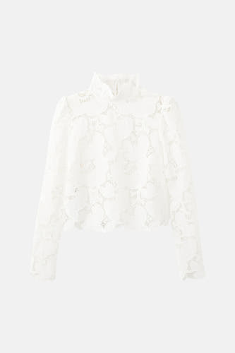 Chemisier blanc à manches longues de MANGO, avec détails en dentelle et col montant.