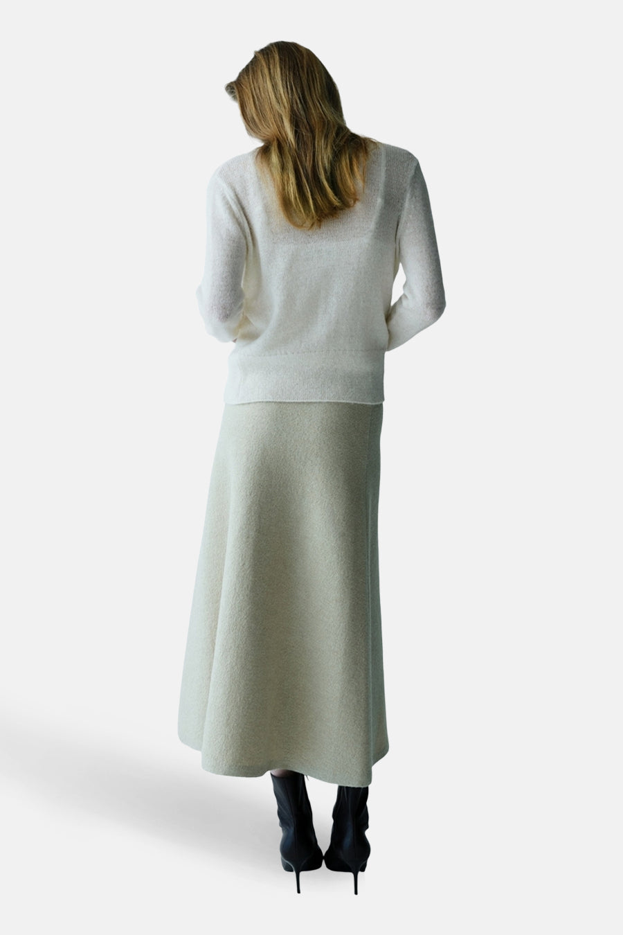 Ecru gilet van MANGO, gezien van achteren, gecombineerd met een lange rok en zwarte laarsjes met hak.
