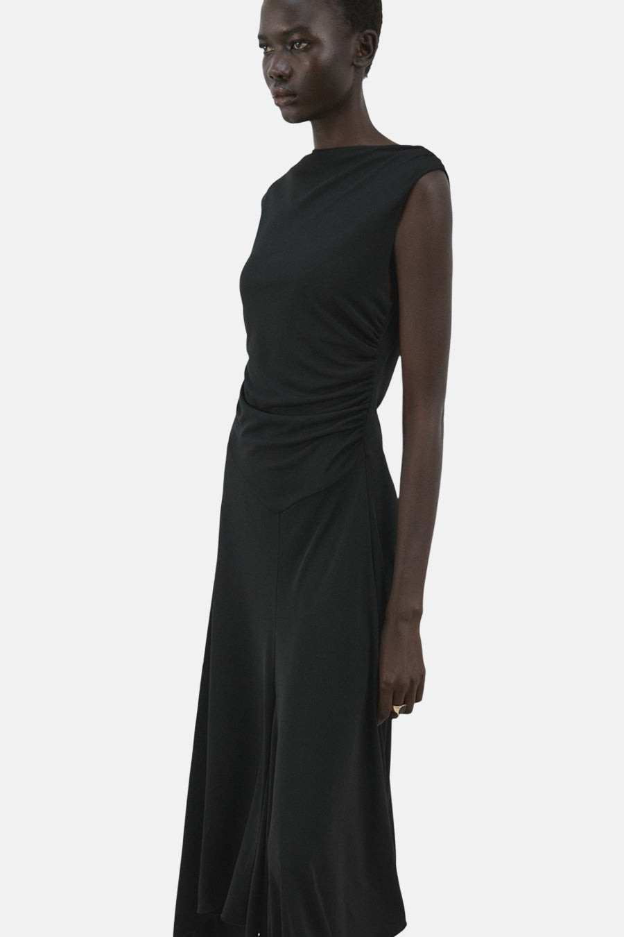 Robe noire sans manches de MANGO, avec détail drapé sur le côté et jupe évasée.