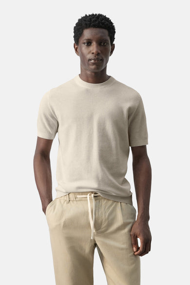 T-shirt beige à manches courtes de MANGO, vu de dos, combiné avec un pantalon kaki.