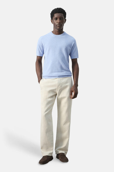 T-shirt bleu à manches courtes de MANGO, porté avec un pantalon beige et des chaussures marron.