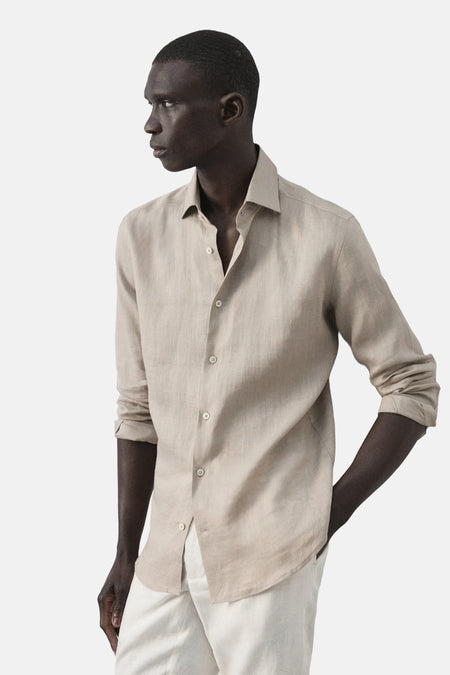 Beige linnen overhemd van MANGO, met lange mouwen en knoopsluiting, gedragen met een witte broek.