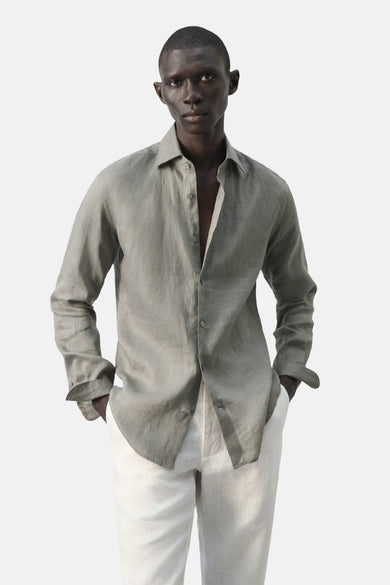 Chemise marron à manches longues pour homme de MANGO, vue de dos, portée avec un pantalon de couleur crème.