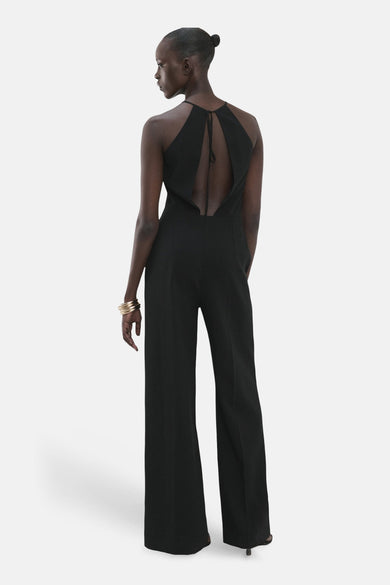 Zwarte jumpsuit van MANGO, met open rug en brede pijpen, gezien van achteren.