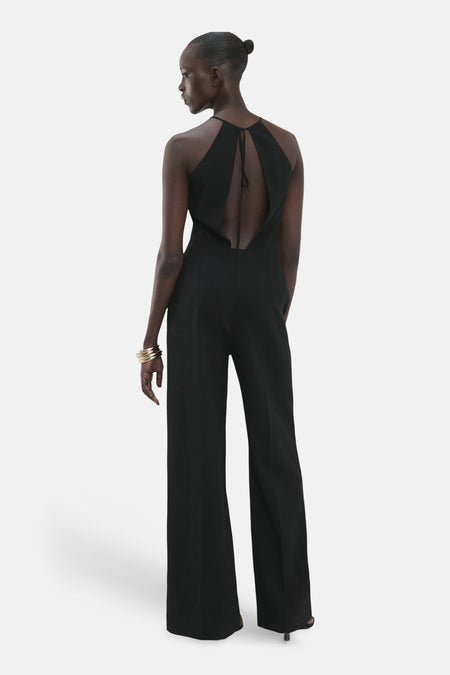 Zwarte jumpsuit van MANGO, met open rug en brede pijpen, gezien van achteren.